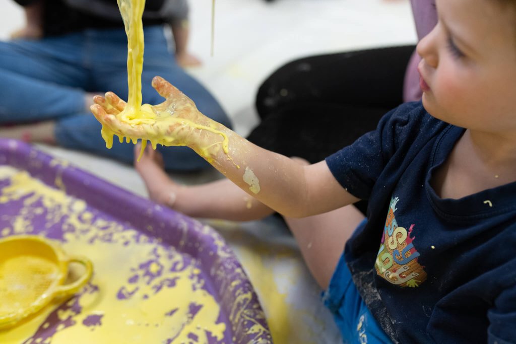 babies-hands-covered-in-yellow-paint