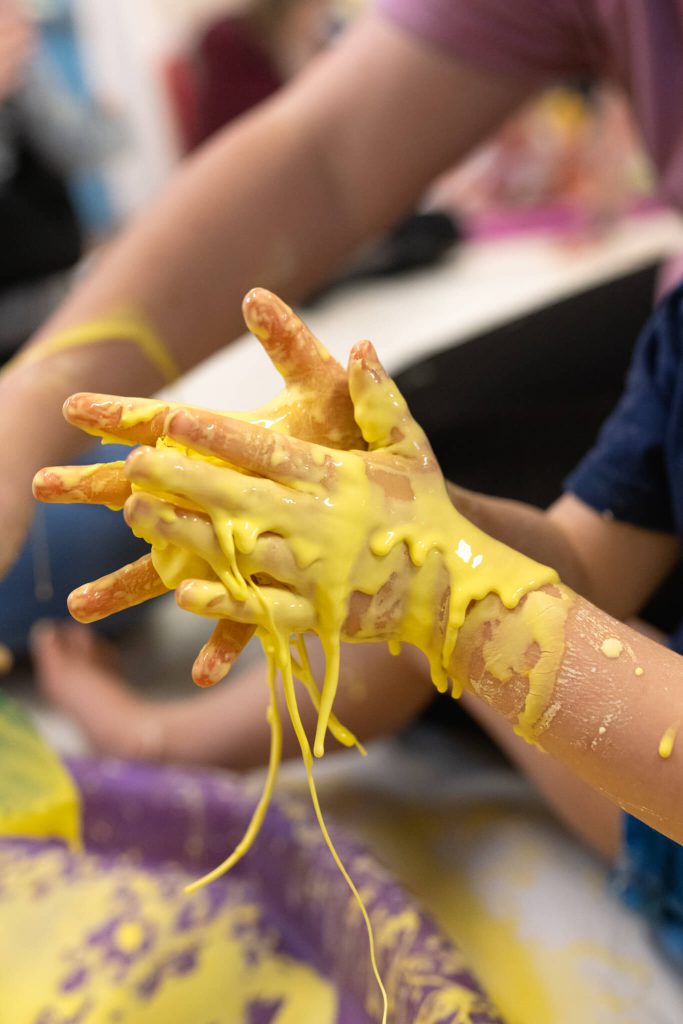 babies-hands-covered-in-yellow-paint