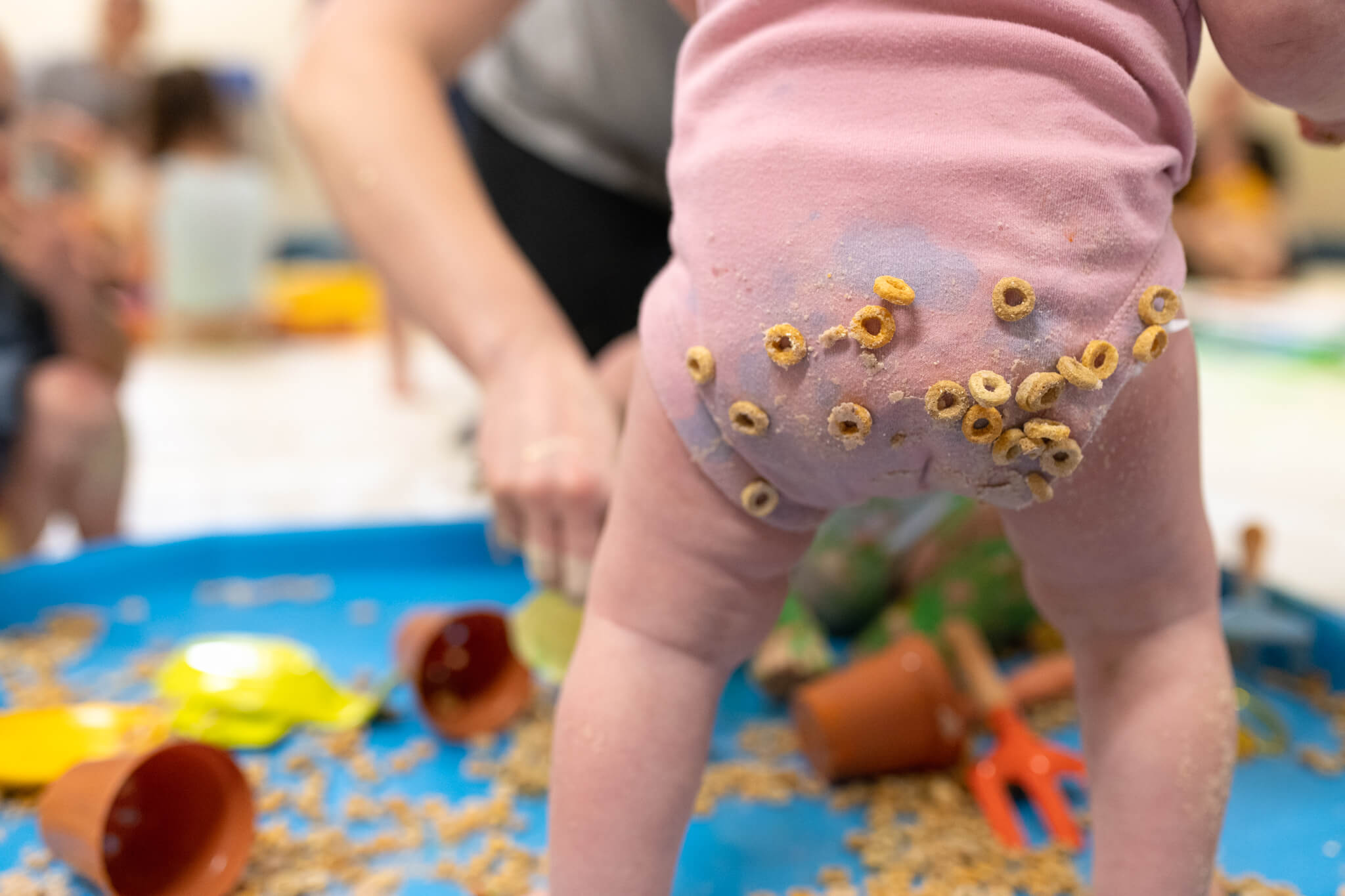 baby-covered-in-cereal-playing-with-toys-and-vegetables