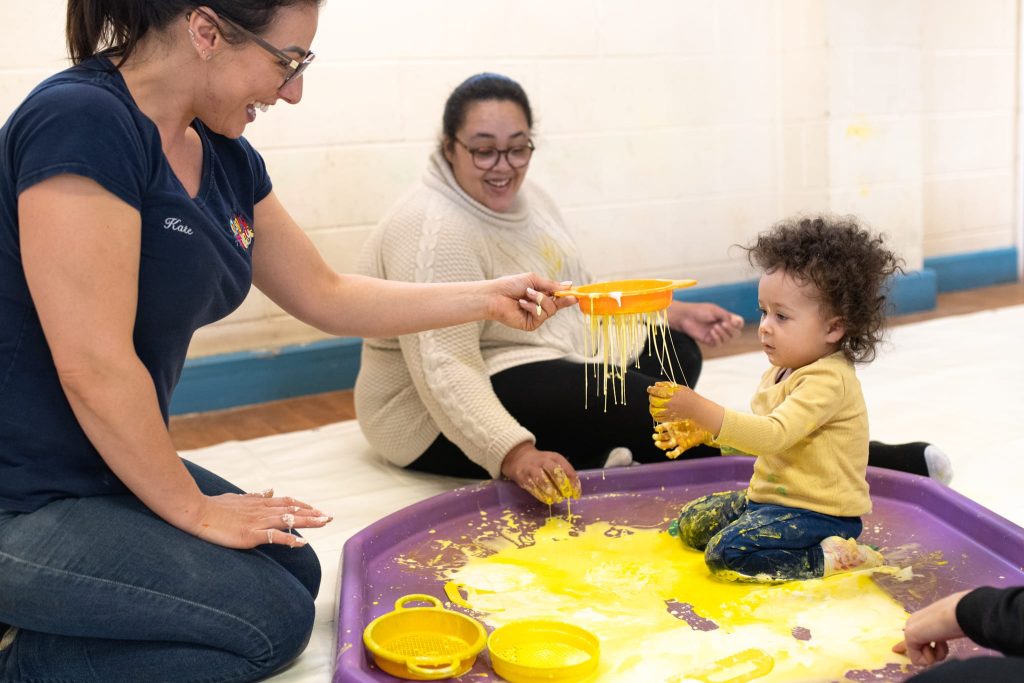 founder-kate-hill-playing-with-the-baby-in-paint