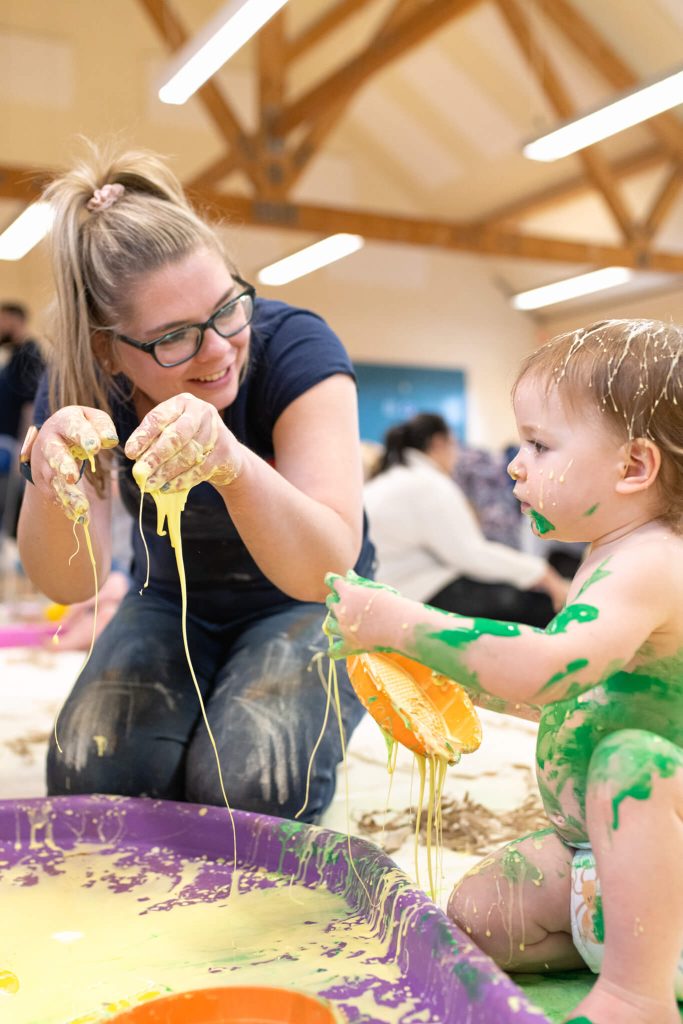 teacher-playing-with-the-baby-covered-in-paint