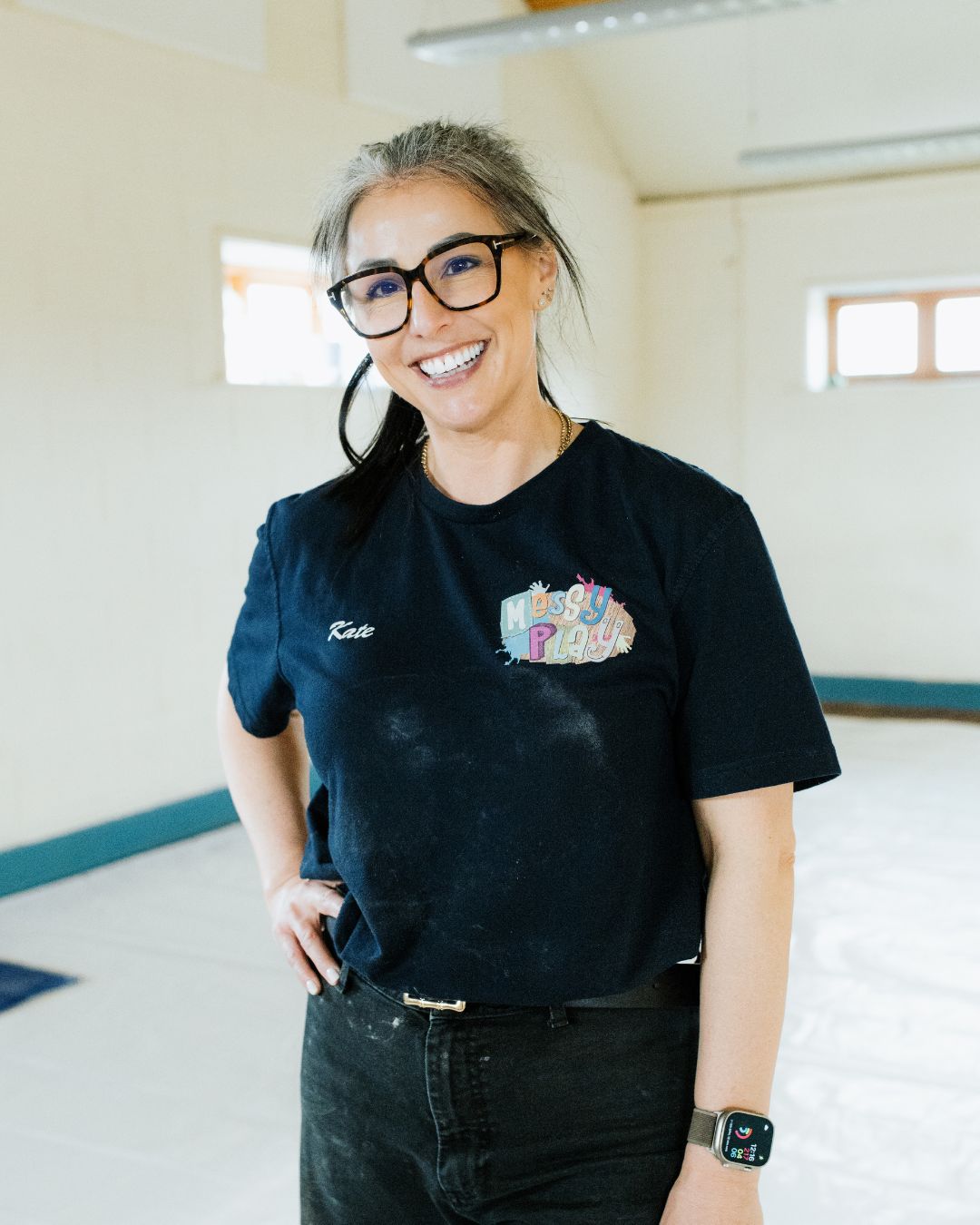 kate the director smiling at the camera in her messy play top